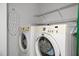 A laundry room features a washer and dryer set, an ironing board and wire shelving at 401 Oak Hollow Ct, Raleigh, NC 27613