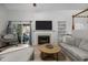Bright living room with fireplace, TV, hardwood floors, and access to the outdoor deck at 401 Oak Hollow Ct, Raleigh, NC 27613