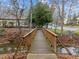 A wooden bridge over a stream in a park setting, leading to a walkway at 401 Oak Hollow Ct, Raleigh, NC 27613