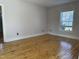 This bedroom has light pink walls, hardwood floors, and a window overlooking the side yard at 4319 Denfield St, Durham, NC 27704