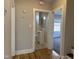 Hallway with an entrance to a full bathroom and a glimpse into a bedroom; hardwood floors throughout at 4319 Denfield St, Durham, NC 27704
