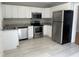 Well lit kitchen featuring stainless steel appliances, white cabinets and updated countertop at 4319 Denfield St, Durham, NC 27704