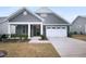 Charming home exterior with stone accents, a two-car garage, covered porch, and landscaped front yard at 475 Bramble Ln, Clayton, NC 27527