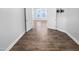 Open-concept living space with wood floors, an adjacent TV mount, and white trim at 475 Bramble Ln, Clayton, NC 27527