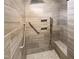 Modern walk-in shower with tiled walls, seating, and a convenient grab bar for accessibility at 475 Bramble Ln, Clayton, NC 27527