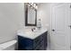 Bathroom vanity features white countertops, navy drawers, and black hardware with a dark framed mirror at 5904 River Lake Cir, Raleigh, NC 27604