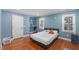 Inviting bedroom features hardwood floors, a plush queen bed and natural light from the windows at 5904 River Lake Cir, Raleigh, NC 27604