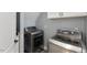 Laundry room with modern appliances, gray walls and cabinets above the appliances at 5904 River Lake Cir, Raleigh, NC 27604