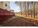 Expansive backyard combines a wooded area with a wide, grassy space and a deck at 601 Walcott Way, Cary, NC 27519