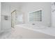 Bathroom featuring a jetted tub with glass block window and shower at 601 Walcott Way, Cary, NC 27519