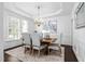 Formal dining room featuring a modern chandelier, tray ceiling, and large window at 601 Walcott Way, Cary, NC 27519