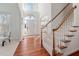 Bright foyer with hardwood floors, staircase, high ceilings, and arched doorway at 601 Walcott Way, Cary, NC 27519