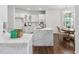 Kitchen with a large marble island, white cabinets, stainless steel appliances, and hardwood floors at 601 Walcott Way, Cary, NC 27519