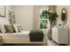 Well-lit bedroom with a full-length mirror and leafy green plants at 712 Shea Hill Dr, Angier, NC 27501