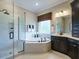 Contemporary bathroom with a glass-enclosed shower, soaking tub, and dark vanity at 1005 Keith Rd, Wake Forest, NC 27587
