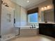 A bathroom featuring a soaking tub, glass-enclosed shower, and a double vanity with dark cabinets at 1005 Keith Rd, Wake Forest, NC 27587