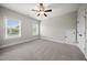 Bright bedroom with two windows, neutral carpet, ceiling fan, and a closet at 1005 Keith Rd, Wake Forest, NC 27587