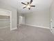 Spacious bedroom with neutral carpet, a ceiling fan, closet, and exterior door at 1005 Keith Rd, Wake Forest, NC 27587