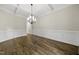 Charming dining room features hardwood floors, wainscoting, a modern chandelier, and is ready for memorable meals at 1005 Keith Rd, Wake Forest, NC 27587