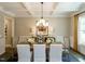 Well-lit dining room with coffered ceilings and a chandelier above a table setting at 1005 Keith Rd, Wake Forest, NC 27587