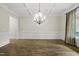 Well-appointed dining room boasts hardwood floors, custom wainscoting, a stylish chandelier, and a bright inviting ambiance at 1005 Keith Rd, Wake Forest, NC 27587