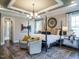Spacious primary bedroom with tray ceiling, accent wall and sitting area with natural light at 1005 Keith Rd, Wake Forest, NC 27587
