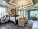 Spacious primary bedroom with tray ceiling, accent wall and sitting area with natural light at 1005 Keith Rd, Wake Forest, NC 27587