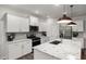 Modern kitchen features white cabinets, a stainless steel refrigerator and a large island with a sink at 1017 Freestone Rd, Durham, NC 27703