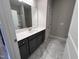 Bathroom showcasing gray vanity, marble tile floors, and a large, bright mirror at 1063 Fairhaven Dr # 54, Mebane, NC 27302