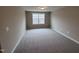 A bright bedroom featuring a large window and neutral-colored carpeting at 1063 Fairhaven Dr # 54, Mebane, NC 27302