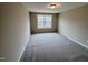 A bright bedroom featuring a large window and neutral-colored carpeting at 1063 Fairhaven Dr # 54, Mebane, NC 27302