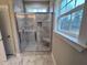 Bright bathroom shower with stone tile and a bench seat and exterior views at 1063 Fairhaven Dr # 54, Mebane, NC 27302