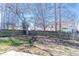 Backyard featuring a wood fence, brick border, and mature trees at 117 Crabwall Ct, Holly Springs, NC 27540