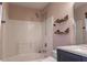 Bathroom boasting a shower-tub combo with modern fixtures and stylish shelving at 117 Crabwall Ct, Holly Springs, NC 27540