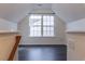 Upstairs bonus room featuring gray wood floors, neutral walls, and a dormer window at 117 Crabwall Ct, Holly Springs, NC 27540