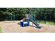 Community playground with slide, climbing structure, tunnel, and swing set surrounded by lush greenery at 117 Crabwall Ct, Holly Springs, NC 27540