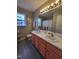 Well-lit bathroom featuring a double vanity, framed mirror, and decorative window at 1317 Justin Oaks Ct, Willow Springs, NC 27592
