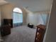 Cozy bedroom featuring neutral walls, carpet and a striking arch window with blue curtains at 1317 Justin Oaks Ct, Willow Springs, NC 27592