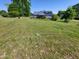 Exterior of home on a large green lawn and mature trees offering a beautiful and peaceful setting at 1317 Justin Oaks Ct, Willow Springs, NC 27592