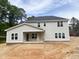 Rear view of gray two-story home with a covered porch and ample windows, surrounded by green trees at 1663 Keith Hills Rd, Lillington, NC 27546