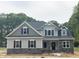 Charming two-story home with stone accents and a neatly landscaped yard under a cloudy sky at 1663 Keith Hills Rd, Lillington, NC 27546