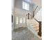 Elegant foyer with a white staircase and a front door with glass accents under a clerestory window at 1663 Keith Hills Rd, Lillington, NC 27546