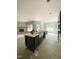 Open-concept kitchen with a dark island and a view into the living room with fireplace and large windows at 1663 Keith Hills Rd, Lillington, NC 27546