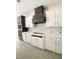 Modern kitchen with white cabinets, gray accents, and a stylish black range hood over marble backsplash at 1663 Keith Hills Rd, Lillington, NC 27546