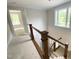 Wooden staircase leading to a well-lit upstairs with view of downstairs entrance at 1663 Keith Hills Rd, Lillington, NC 27546