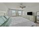 Bright bedroom featuring two windows, a ceiling fan, and a dresser with TV at 17 Donatella Way, Angier, NC 27501