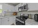 Well-equipped kitchen with stainless steel appliances, white cabinets and granite countertops at 17 Donatella Way, Angier, NC 27501