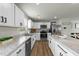 Bright kitchen features white cabinets, stainless steel appliances, and a granite countertop island at 17 Donatella Way, Angier, NC 27501