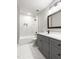 Bathroom features gray vanity, white countertop, framed mirror, and shower over tub with marble style tiling at 200 Single Tree Cir, Haw River, NC 27258
