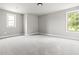 This bedroom features neutral carpet, light gray walls, a ceiling mounted light, and natural light from two windows at 200 Single Tree Cir, Haw River, NC 27258